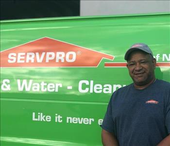 Servpro rep standing in front of a company vehicle