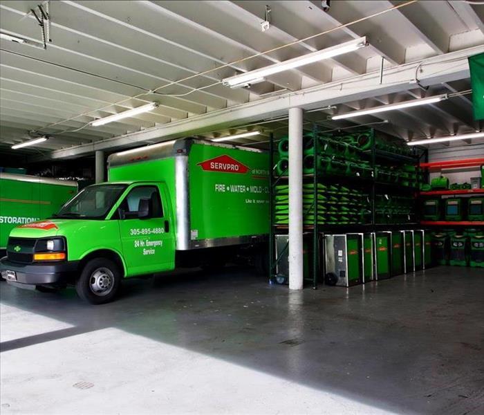 Garage stored with green equipment and a SERVPRO truck. 