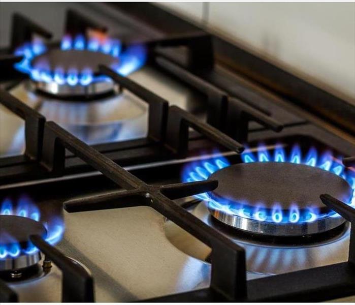 Natural gas burning on kitchen gas stove in the dark.